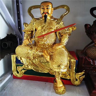 金色鎏金真武大帝銅像，單手持劍一腳盤坐一腳著地的真武祖師塑像